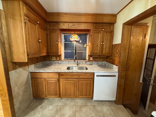 kitchen with pendant lighting, sink, light stone counters, and dishwasher