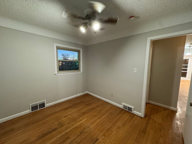 unfurnished room with wood-type flooring, a textured ceiling, and ceiling fan