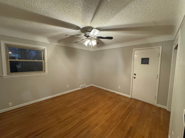 unfurnished room with hardwood / wood-style flooring, ceiling fan, and a textured ceiling