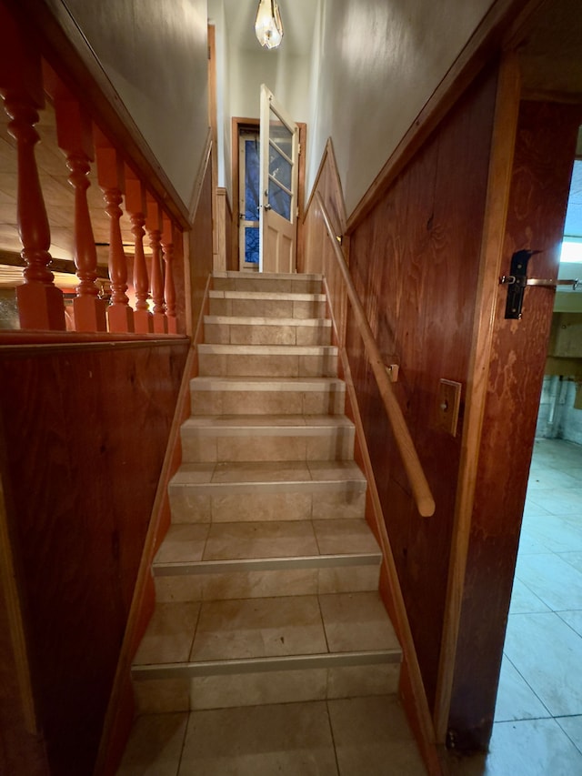 stairs featuring wooden walls