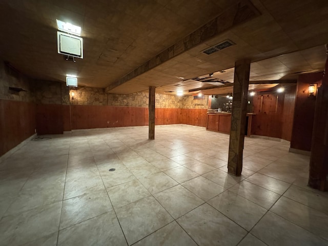 basement featuring wooden walls