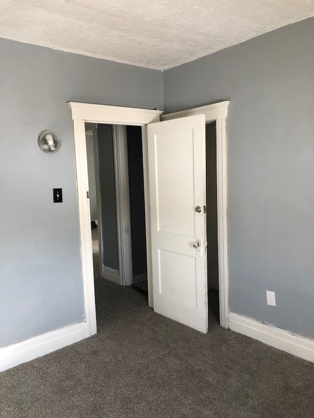 carpeted empty room featuring a textured ceiling