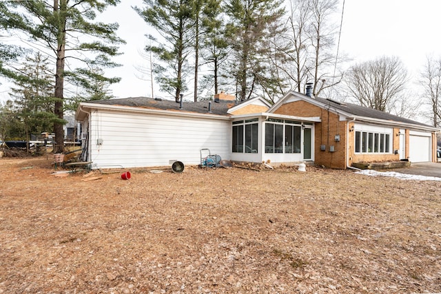 back of property featuring a garage and a sunroom