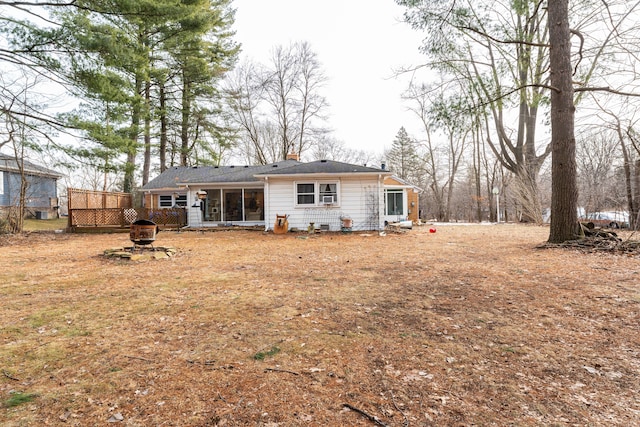 rear view of property featuring an outdoor fire pit