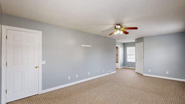 carpeted spare room with ceiling fan and a textured ceiling