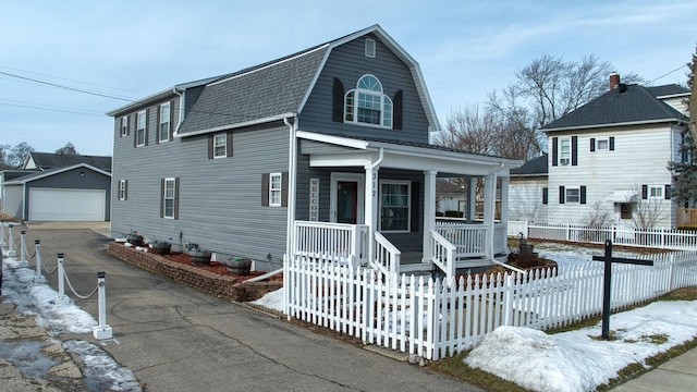 view of property featuring an outbuilding, a garage, and a porch