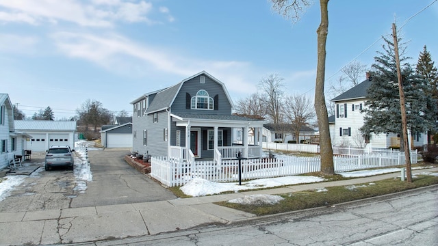 view of front of property featuring a garage, an outdoor structure, and a porch