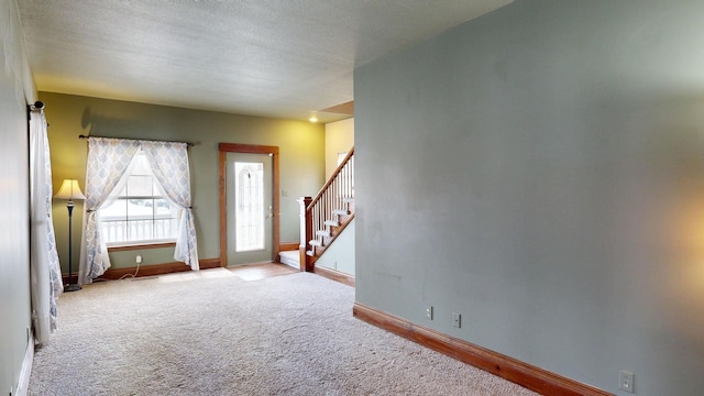 interior space with light carpet and a textured ceiling