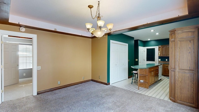 kitchen featuring white dishwasher, hanging light fixtures, light carpet, and a kitchen island