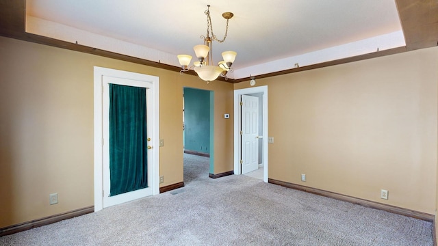 carpeted spare room featuring a notable chandelier