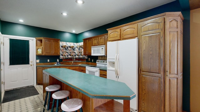 kitchen featuring a center island, a kitchen bar, sink, and white appliances