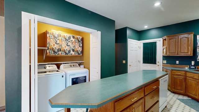 kitchen with washer and dryer, dishwasher, and a kitchen island