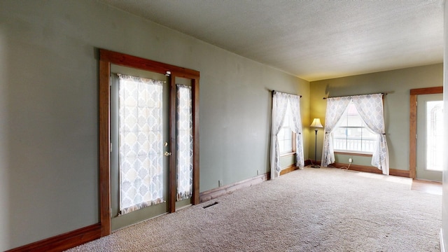 spare room with carpet flooring and a textured ceiling