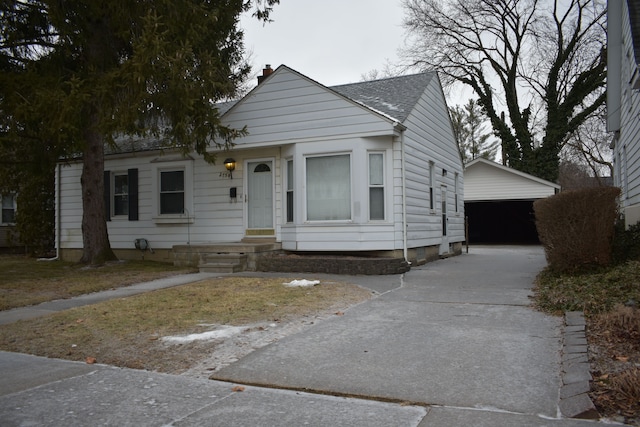 bungalow-style house featuring a garage and an outbuilding