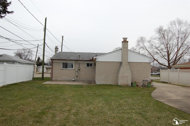 rear view of property featuring a patio and a lawn