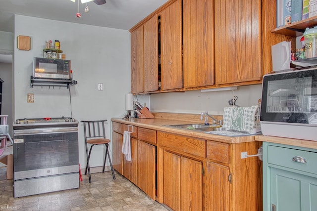 kitchen featuring appliances with stainless steel finishes, sink, and ceiling fan