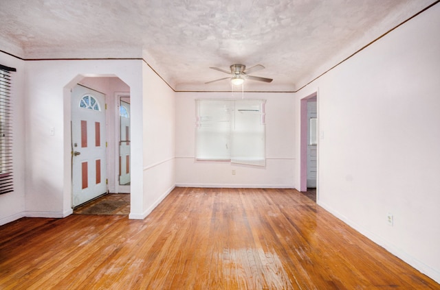 empty room with crown molding, light hardwood / wood-style flooring, and a textured ceiling