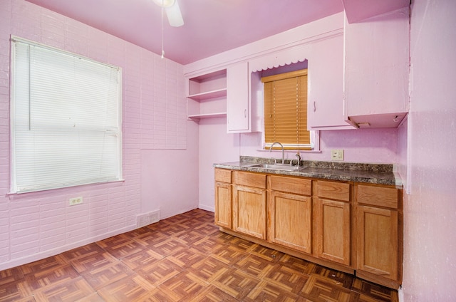 kitchen featuring ceiling fan, sink, and dark parquet floors