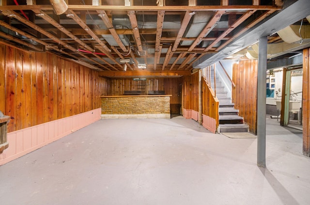 basement featuring wooden walls