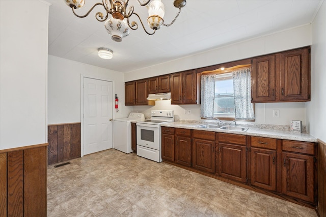 kitchen with electric stove, sink, an inviting chandelier, wooden walls, and washer / clothes dryer