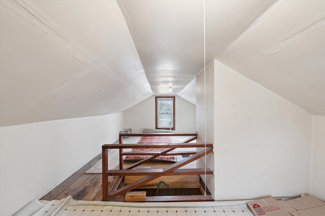 stairs with hardwood / wood-style flooring and vaulted ceiling