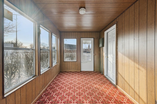 unfurnished sunroom featuring wooden ceiling and a wealth of natural light