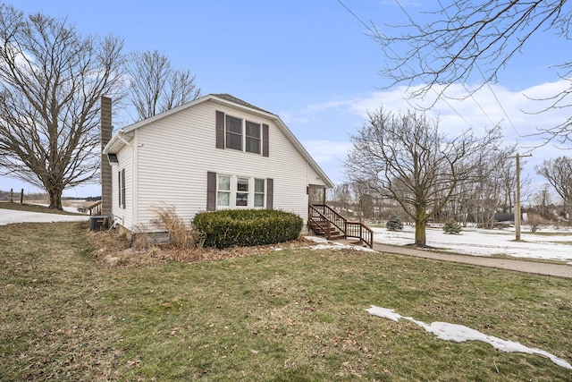 view of side of home featuring central AC and a yard