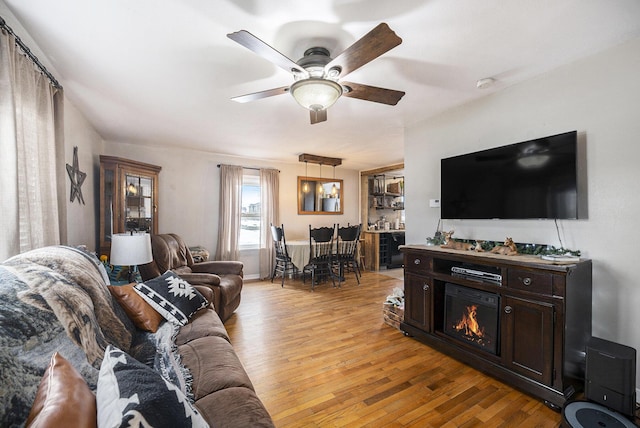 living room with ceiling fan and light wood-type flooring