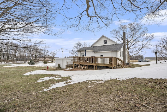 snow covered property featuring a yard and a deck