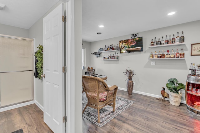 living area featuring wood-type flooring and bar