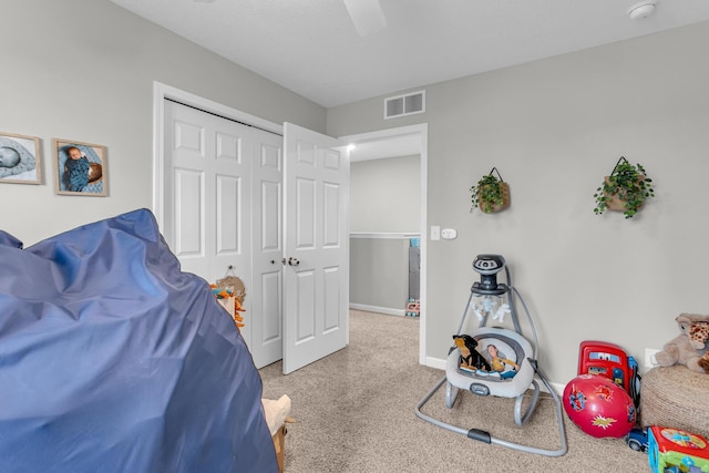 carpeted bedroom featuring ceiling fan and a closet