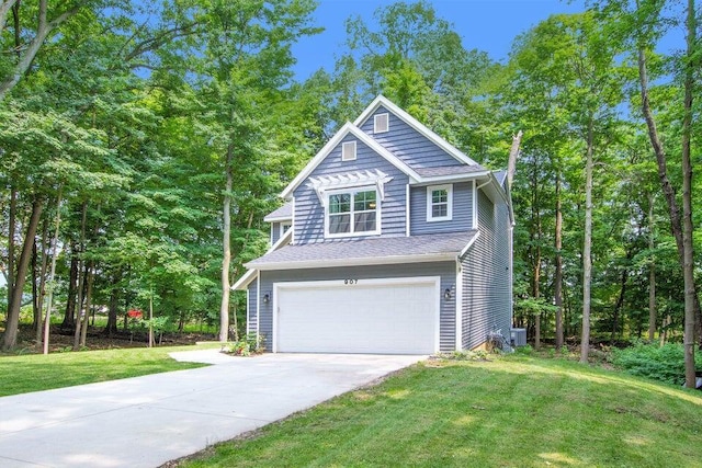 view of front facade featuring a garage, a front yard, and central air condition unit