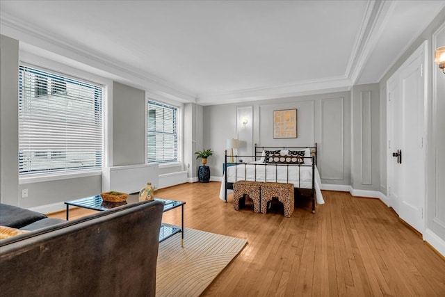 bedroom with ornamental molding and light hardwood / wood-style flooring