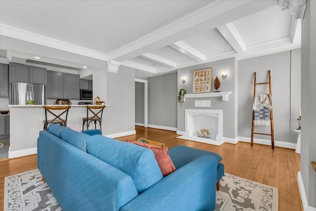 living room featuring beamed ceiling and light hardwood / wood-style floors