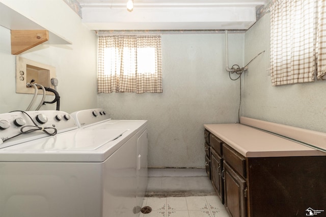 clothes washing area with cabinets and washing machine and clothes dryer