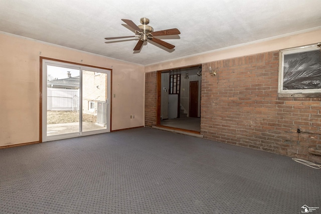 carpeted empty room with ceiling fan and brick wall