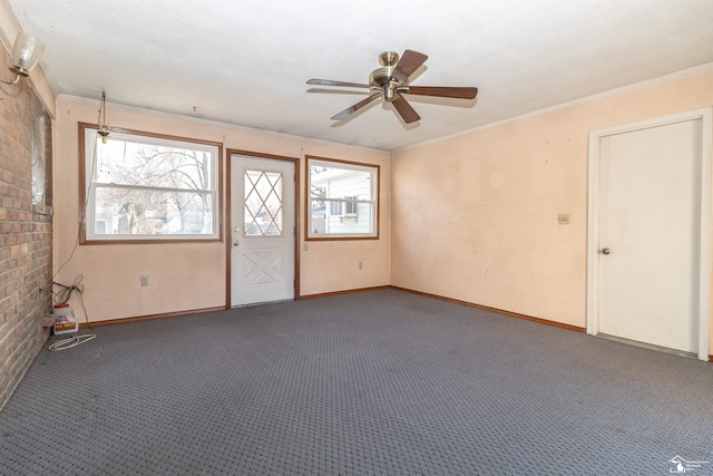 interior space featuring crown molding, ceiling fan, and dark colored carpet