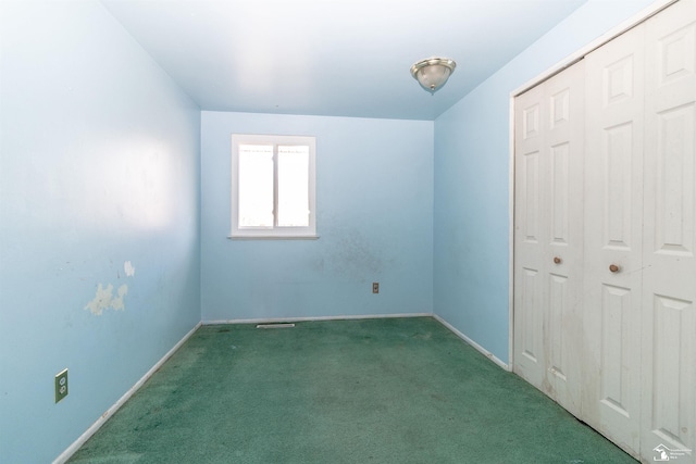 unfurnished bedroom with a closet and dark colored carpet