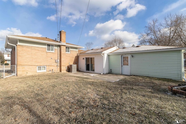 rear view of property with central AC unit, a yard, and a patio area