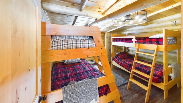 bedroom with rustic walls and wood finished floors