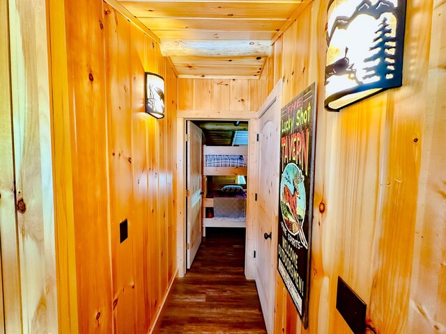 hall with wood finished floors, wooden walls, and wooden ceiling