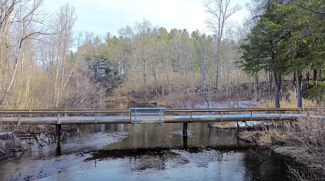 view of dock featuring a forest view and a water view