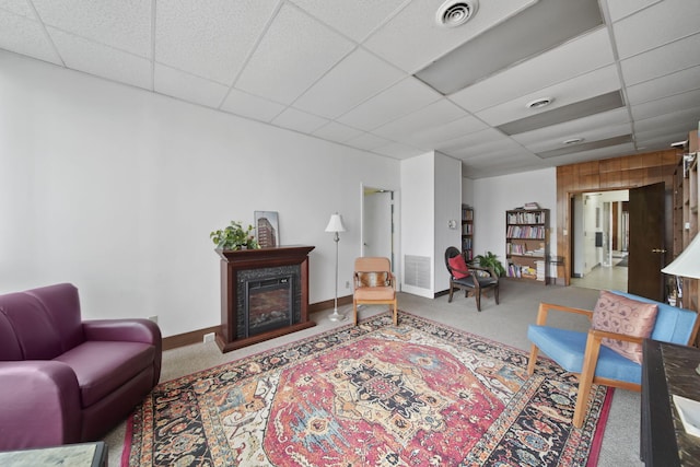 carpeted living room with a drop ceiling