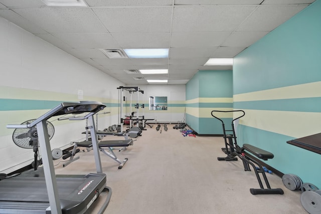 gym featuring a drop ceiling and light colored carpet