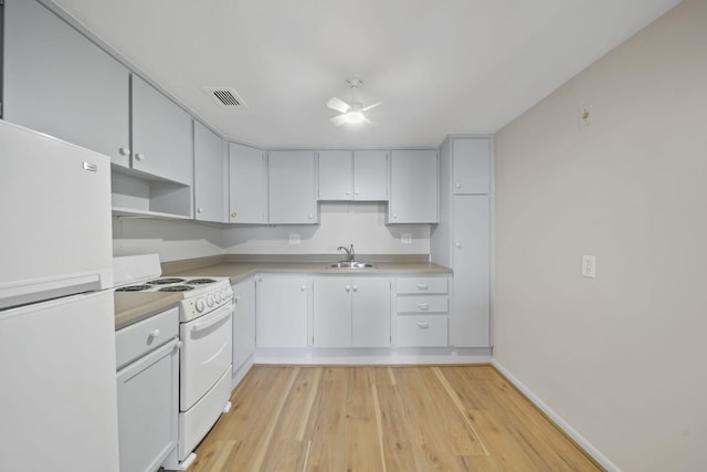 kitchen featuring sink, white cabinets, white appliances, and light wood-type flooring