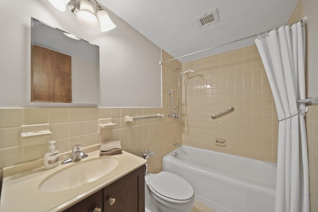 full bathroom with vanity, tile walls, shower / tub combo with curtain, and toilet