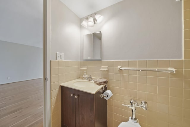 bathroom with tile walls, vanity, and hardwood / wood-style floors