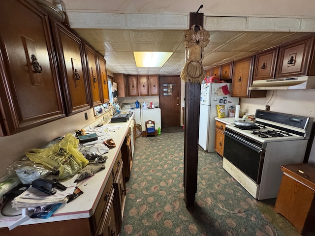 kitchen featuring white appliances and washer and dryer