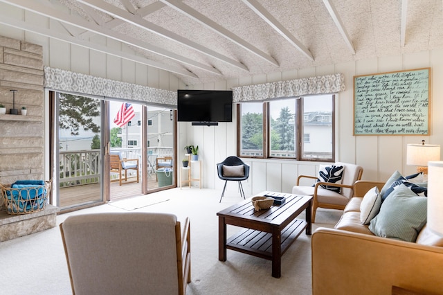 living room with a wealth of natural light, carpet floors, and beamed ceiling