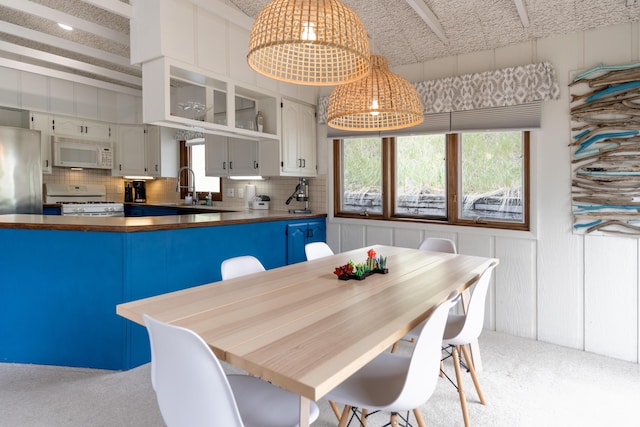 carpeted dining space with plenty of natural light and sink